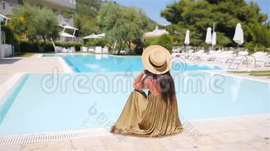 在豪华酒店度假胜地的泳池边放松的女士享受完美的海滩度假